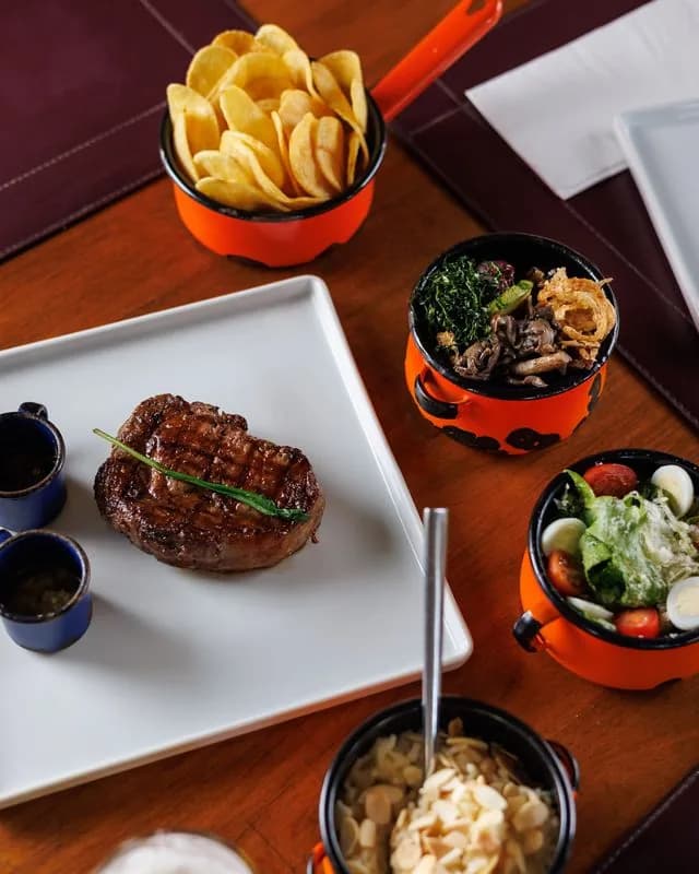 Bife Ancho grelhado e servido no ¡Vení! Parrilla
